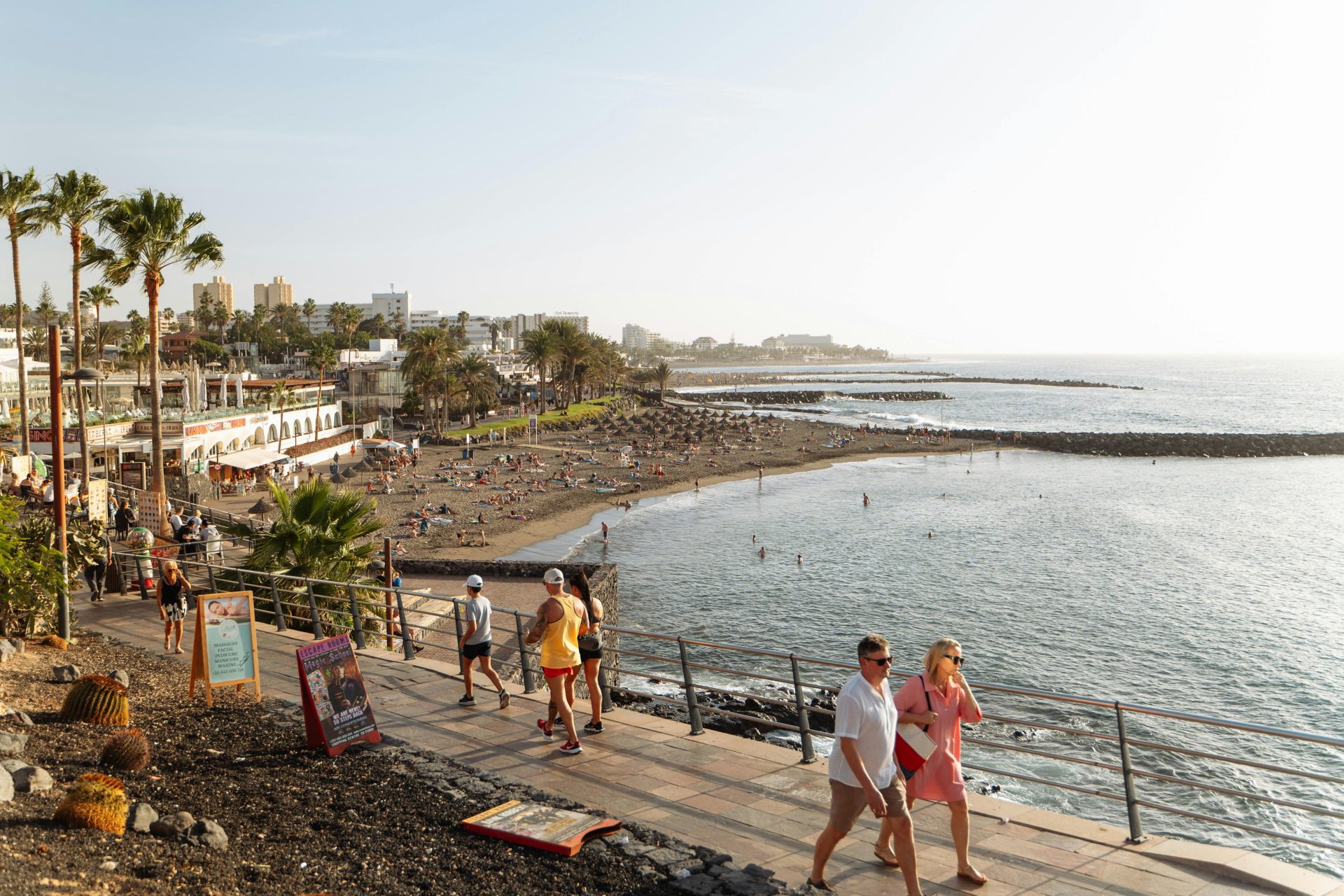 Escena relajante en la playa de Tenerife, España, con bañistas disfrutando del sol.