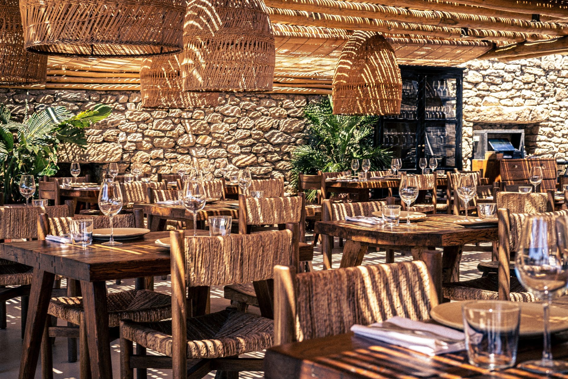 Un restaurante con mesas y sillas de madera y una pared de piedra.